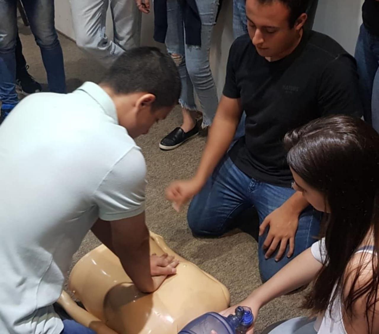 Imagem representando aluno aplicando técnica de reanimação cardipulmonar em um boneco