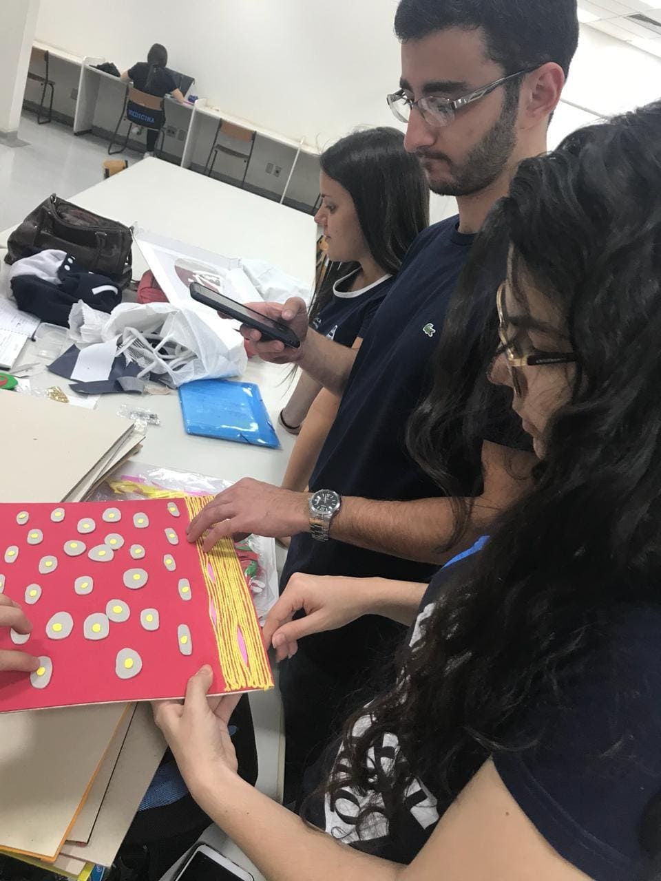 Imagem representando alunos retirando foto das colagem de tecidos