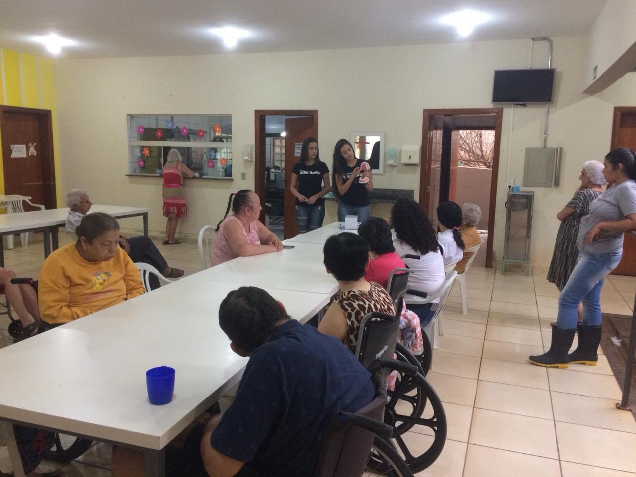 Imagem representando apresentação de integrantes do projeto ensinando idosos a escovar os dentes