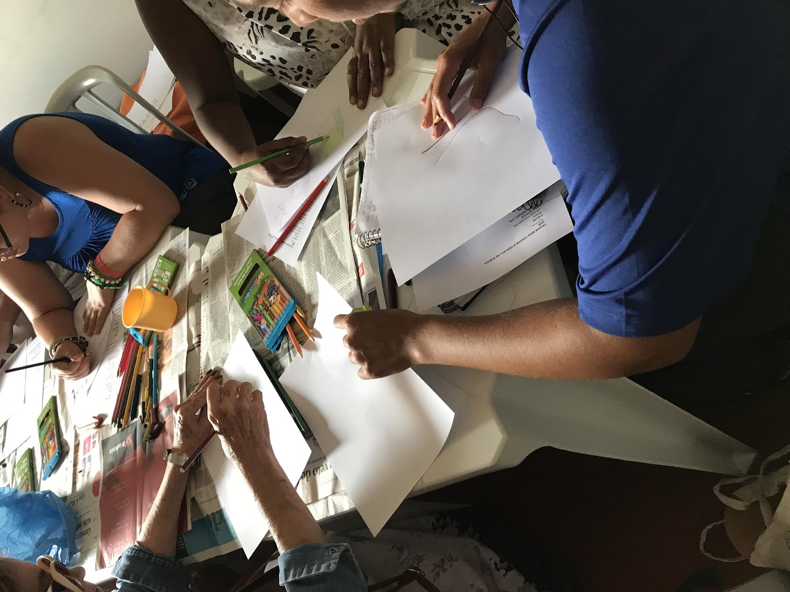 Grupo desenhando e recortando jornal no projeto de rede de leituras