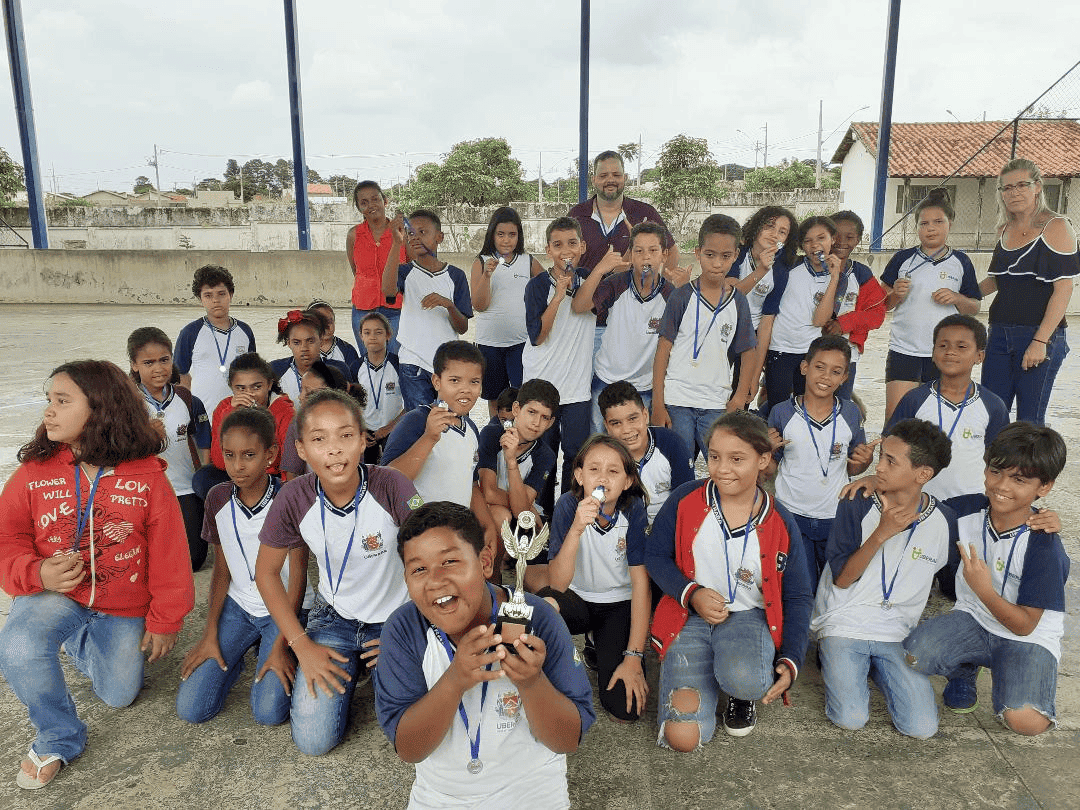Imagem representando crianças reunidas na quadra da escola municipal joubert de carvalho para tirar foto