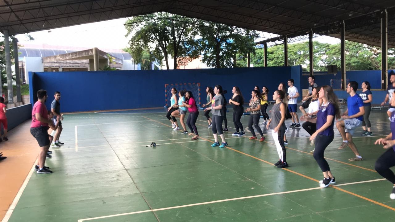 Imagem representando grupo de pessoas fazendo exercício com as pernas na quadra