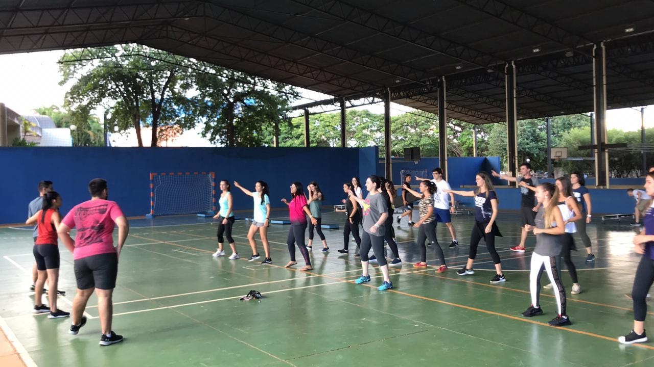 Imagem representando grupo de pessoas fazendo exercícios com o braço na quadra