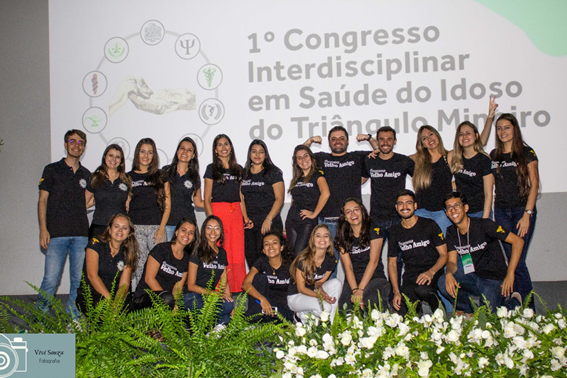 Imagem representando grupo de pessoas retiando foto em frente a telão