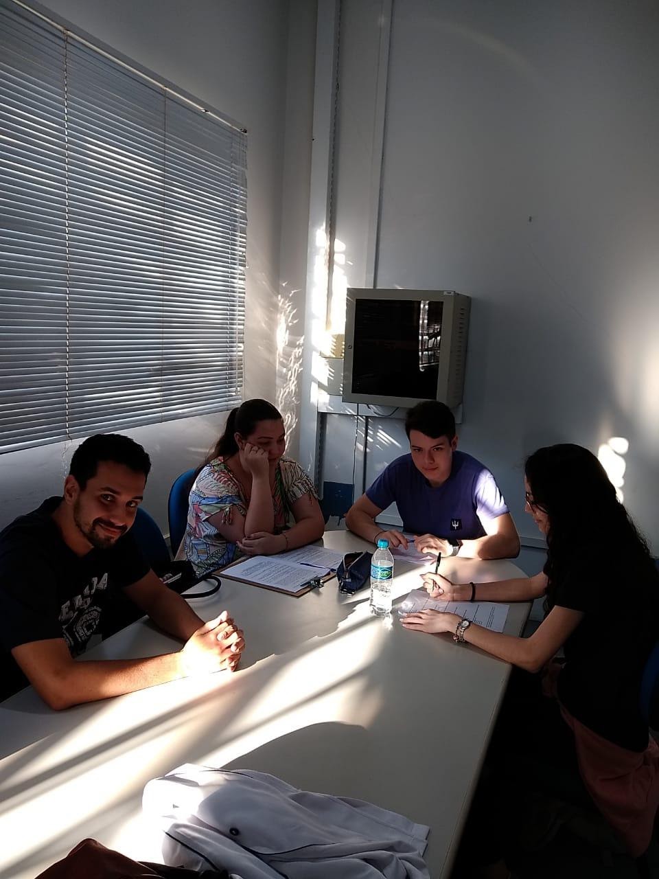 Imagem representando grupo de pessoas sentada em uma mesa