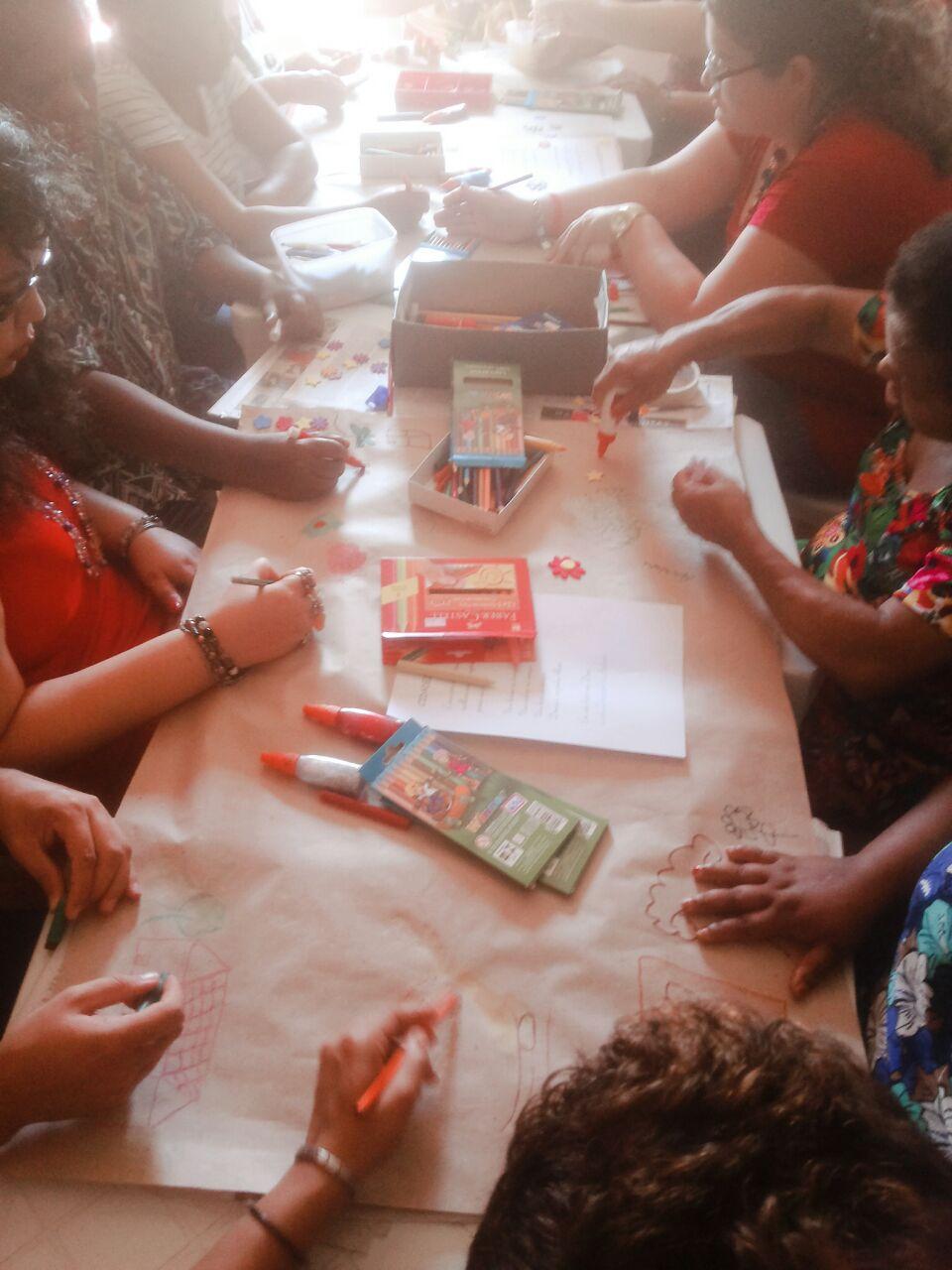Grupo colorindo, pintando e colando estrelas na cartalina no projeto de rede de leituras