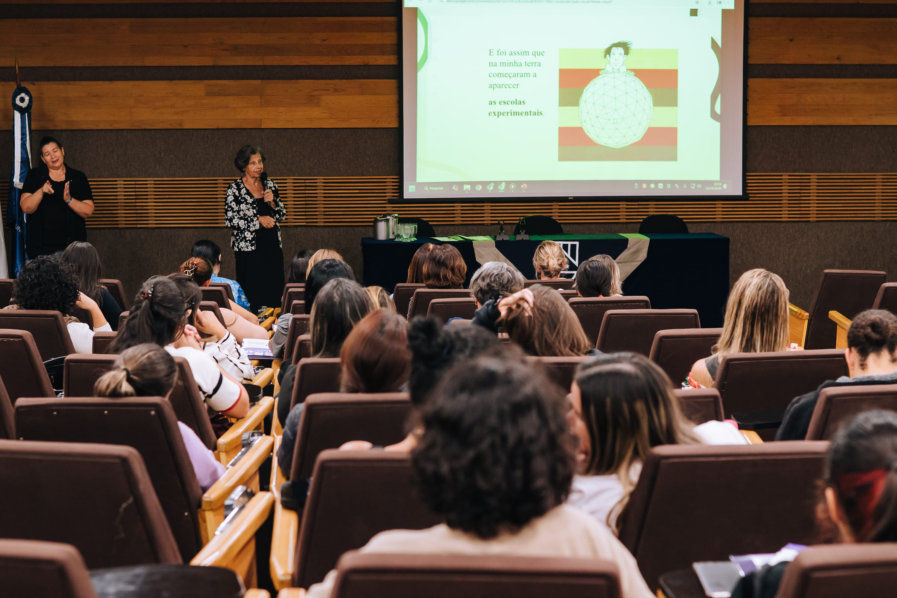 Público acompanhando apresentação acadêmica no auditório do Congresso