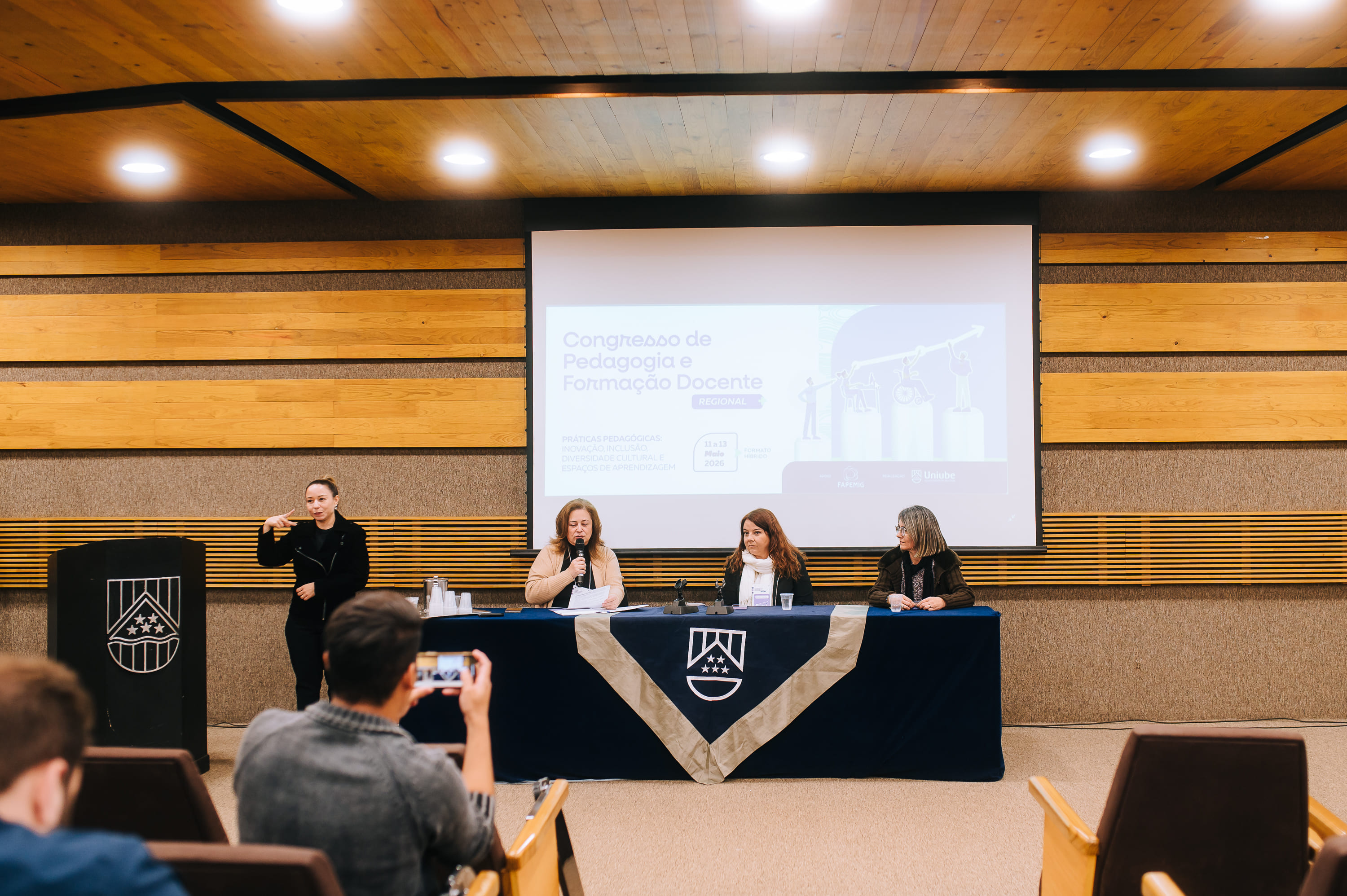 Mesa com participantes e apresentação no auditório do Congresso